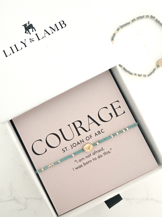 Bracelet on a box with 'Lily & Lamb' branding and text about courage.