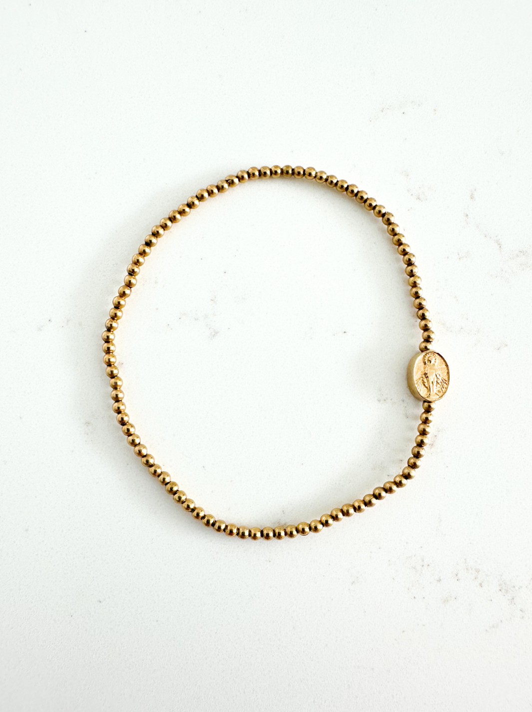 Gold beaded bracelet on a white background