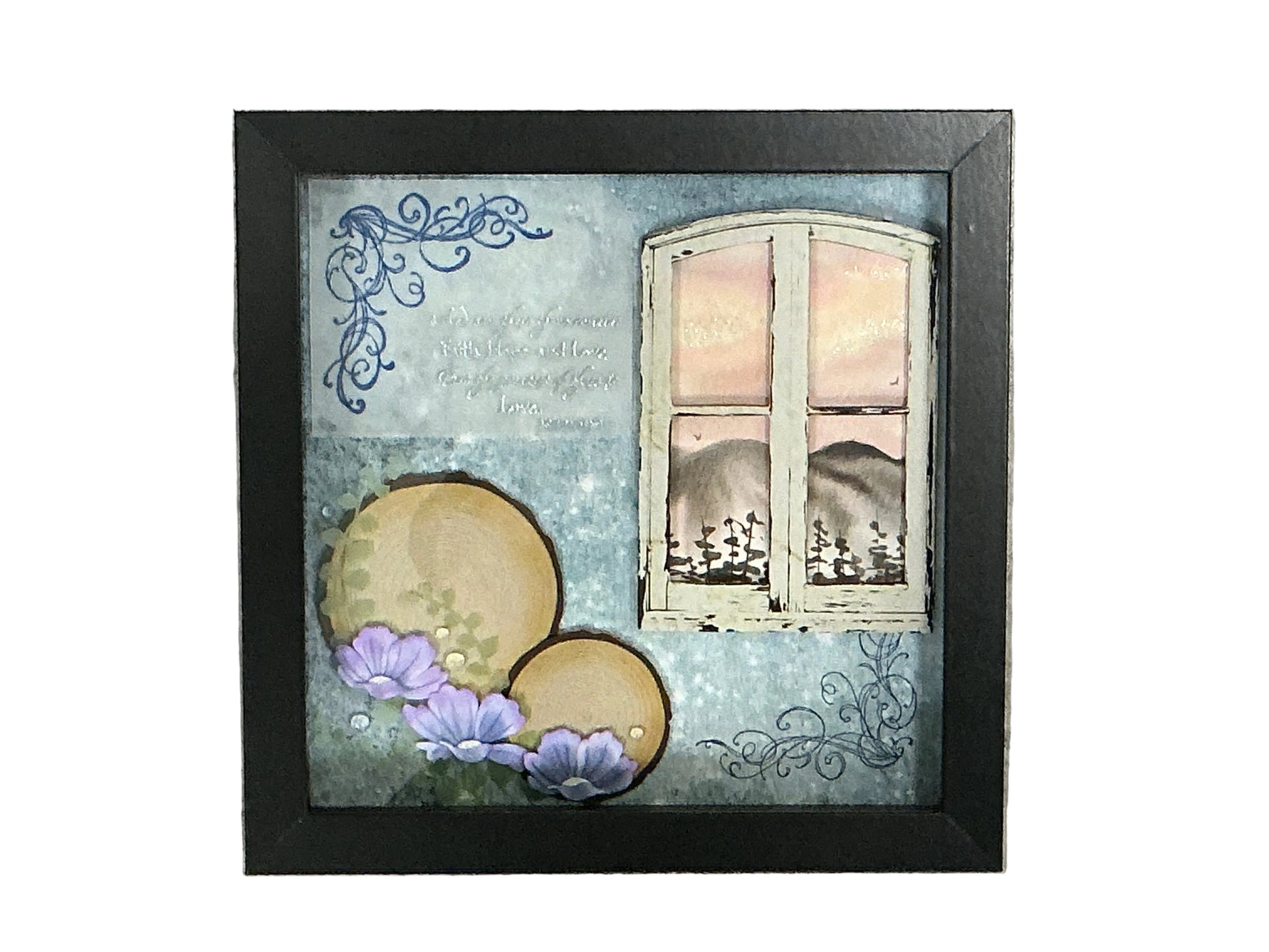 A square black-framed mixed-media art piece featuring a distressed blue background, a white window with pink sky, two gold circles, and purple flowers, displayed on a textured gray surface.