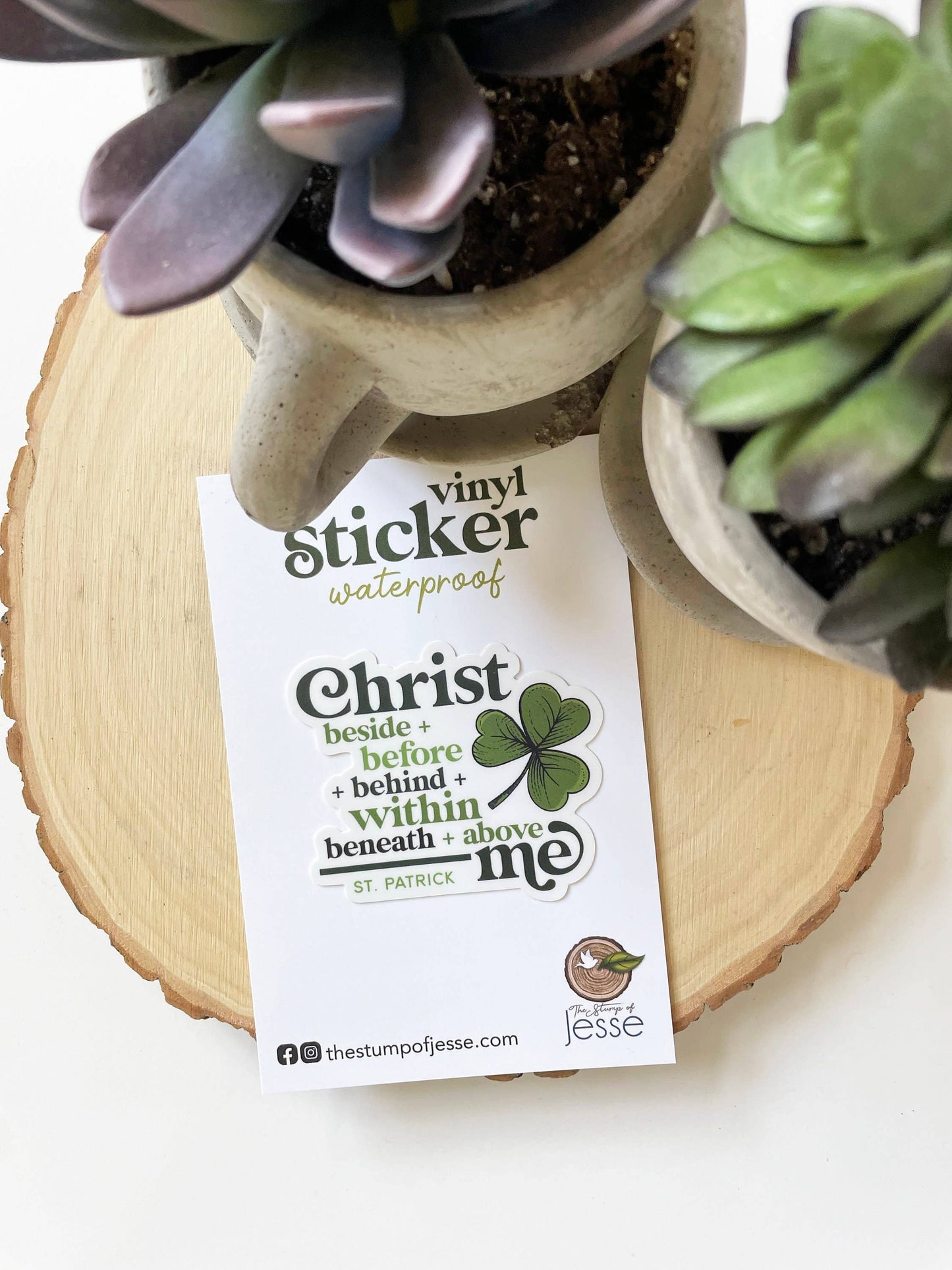 Vinyl sticker with text and clover design on a wooden surface with plants