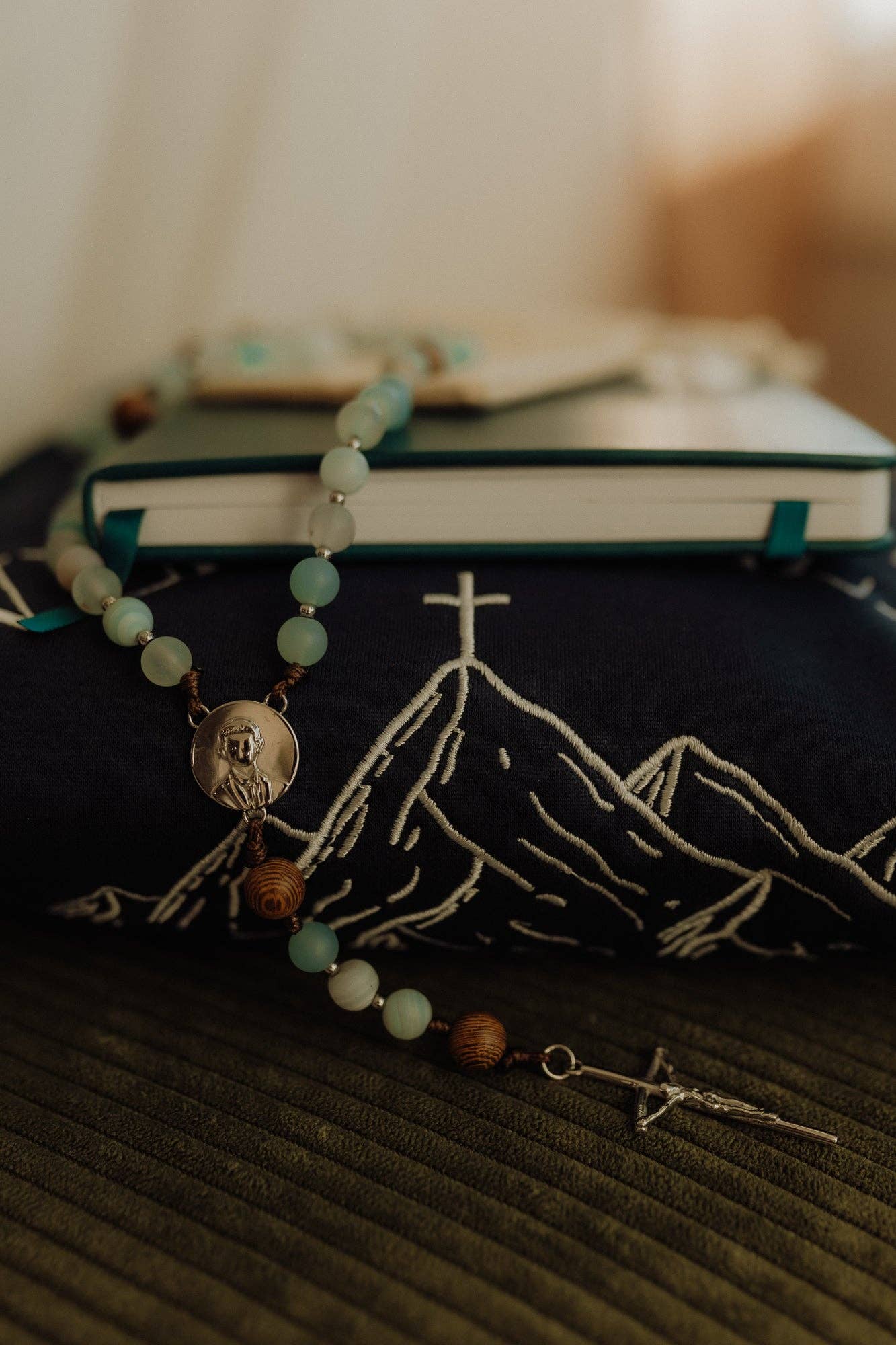 Rosary with mountain design on a book