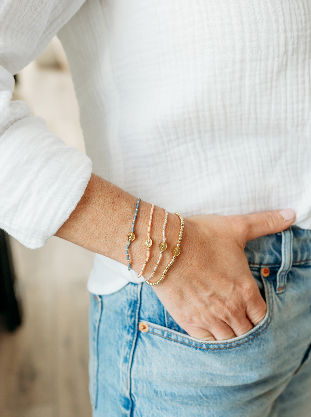 Person wearing multiple gold bracelets on a blurred background