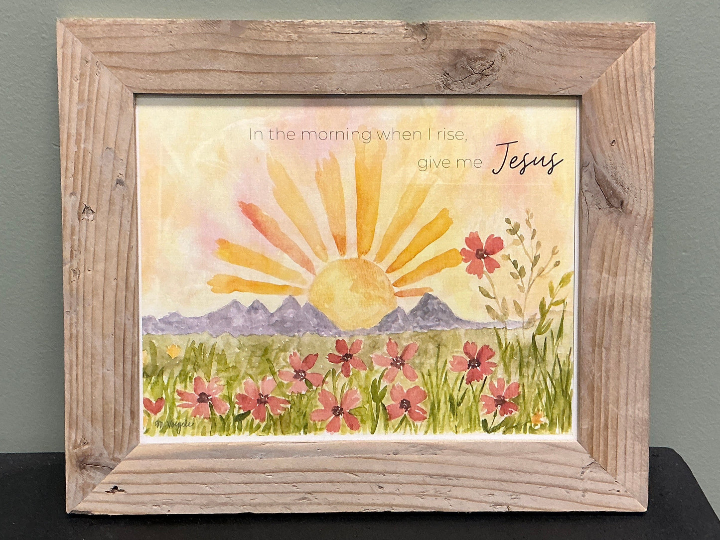 Framed colorful artwork with a sun and mountain scene.