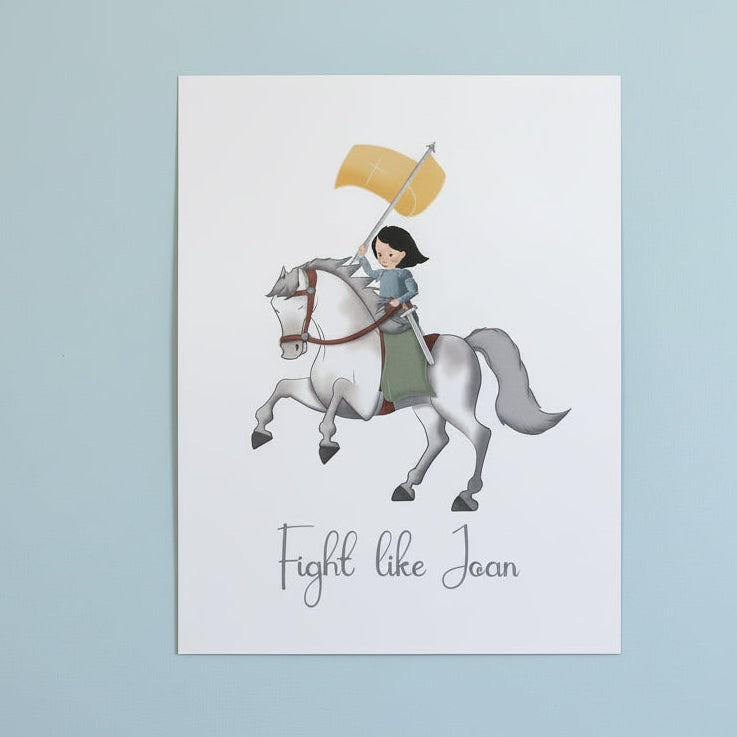 Print with illustration of Joan of Arc on horseback and 'Fight like Joan' text on a white surface.