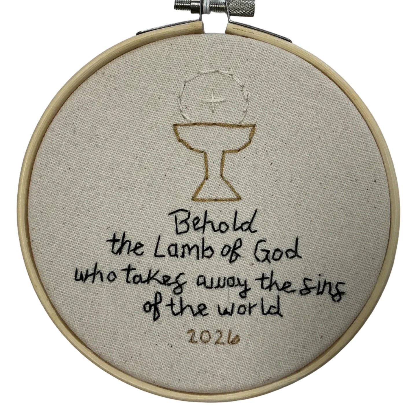 Embroidery hoop with a religious design and text on a white background