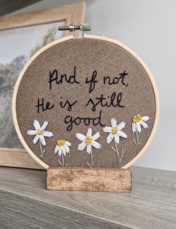 Brown embroidery with daisy flowers on a white and grey background 