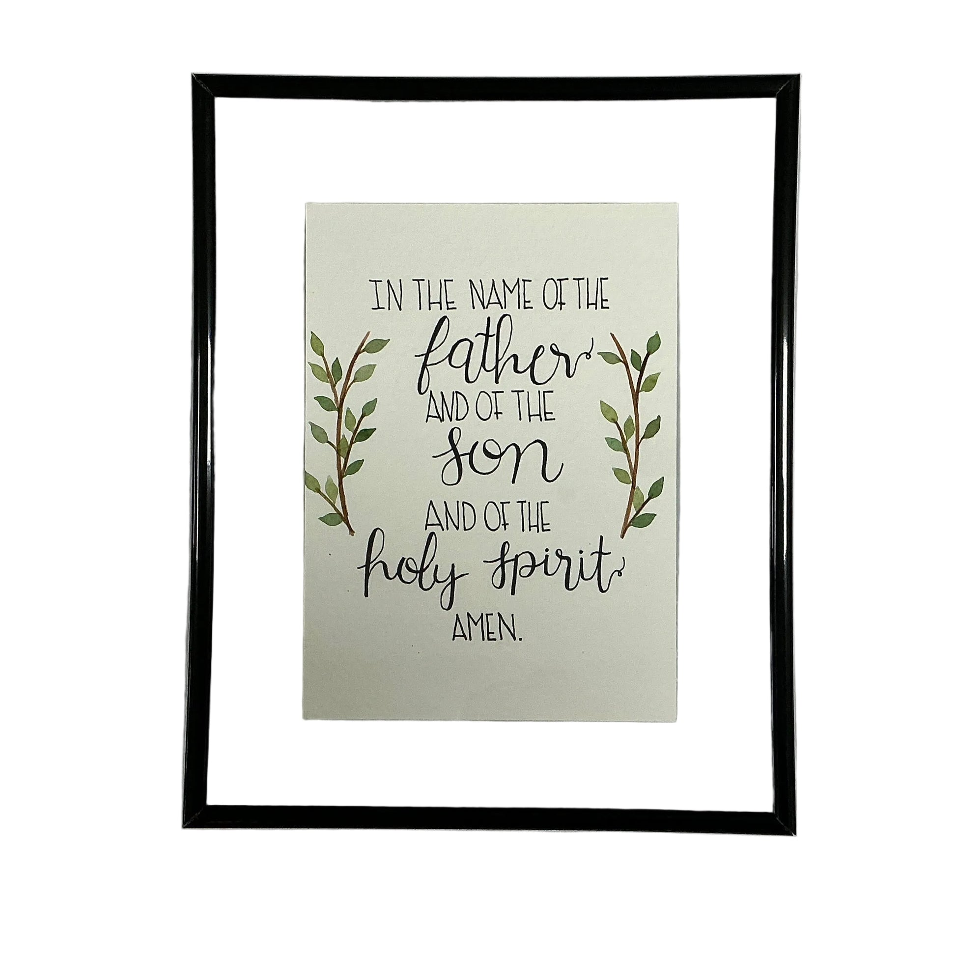 Framed print with religious text and leaves on a white fabric background