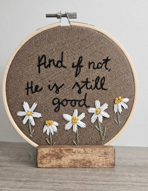 Brown embroidery with daisy flowers on a white and grey background 