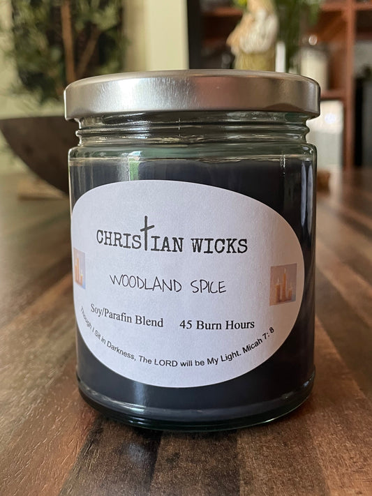 Jar of Christian Wicks Woodland Spice candle on a wooden surface