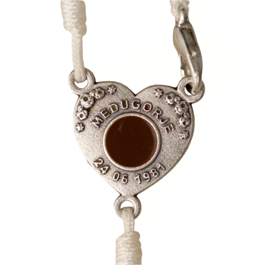 Heart-shaped metal pendant with 'Medugorje' text on a white background