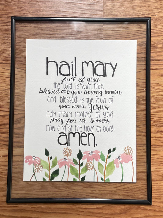 Framed print with floral design and text on a wooden floor