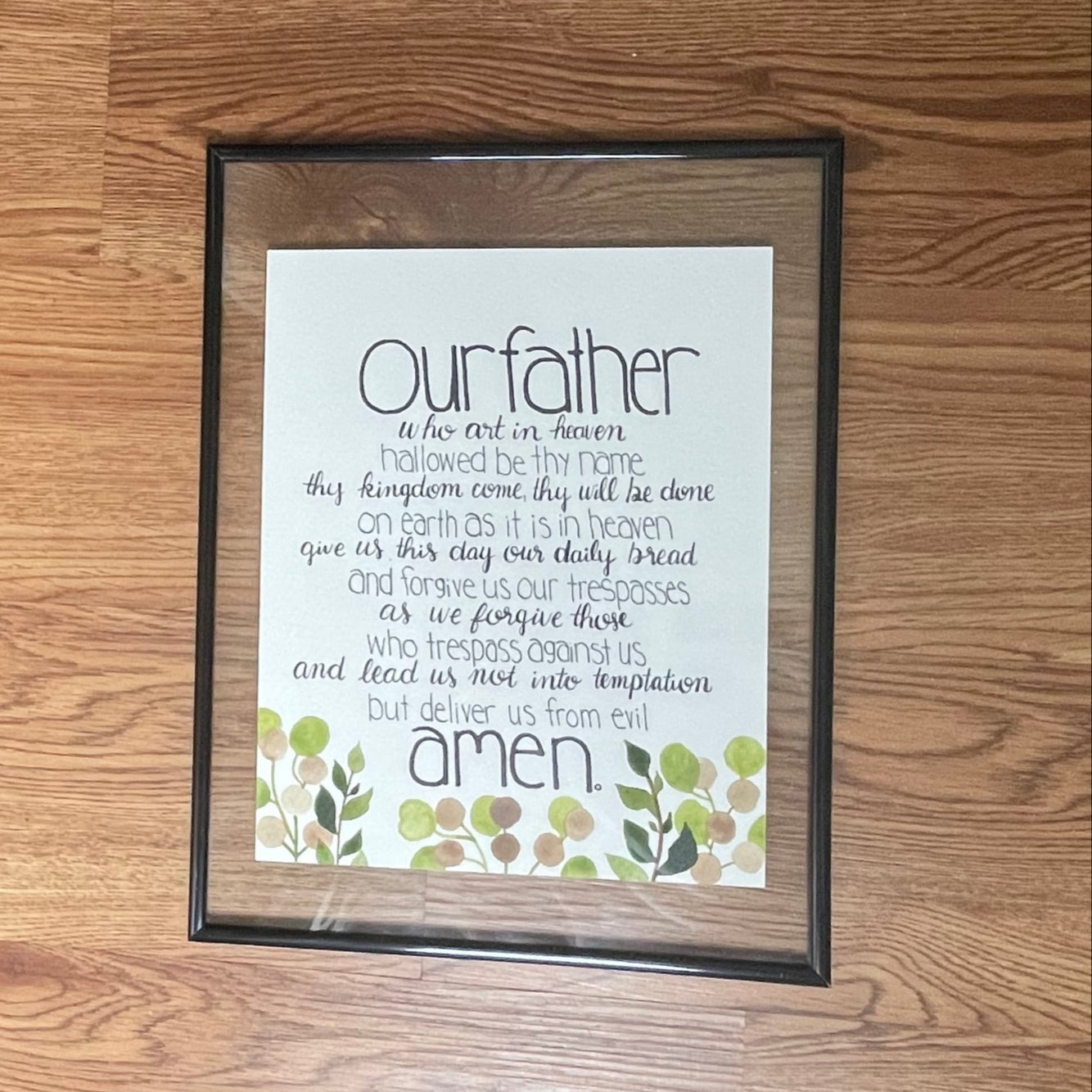 Framed print on a wooden floor next to a textured wall