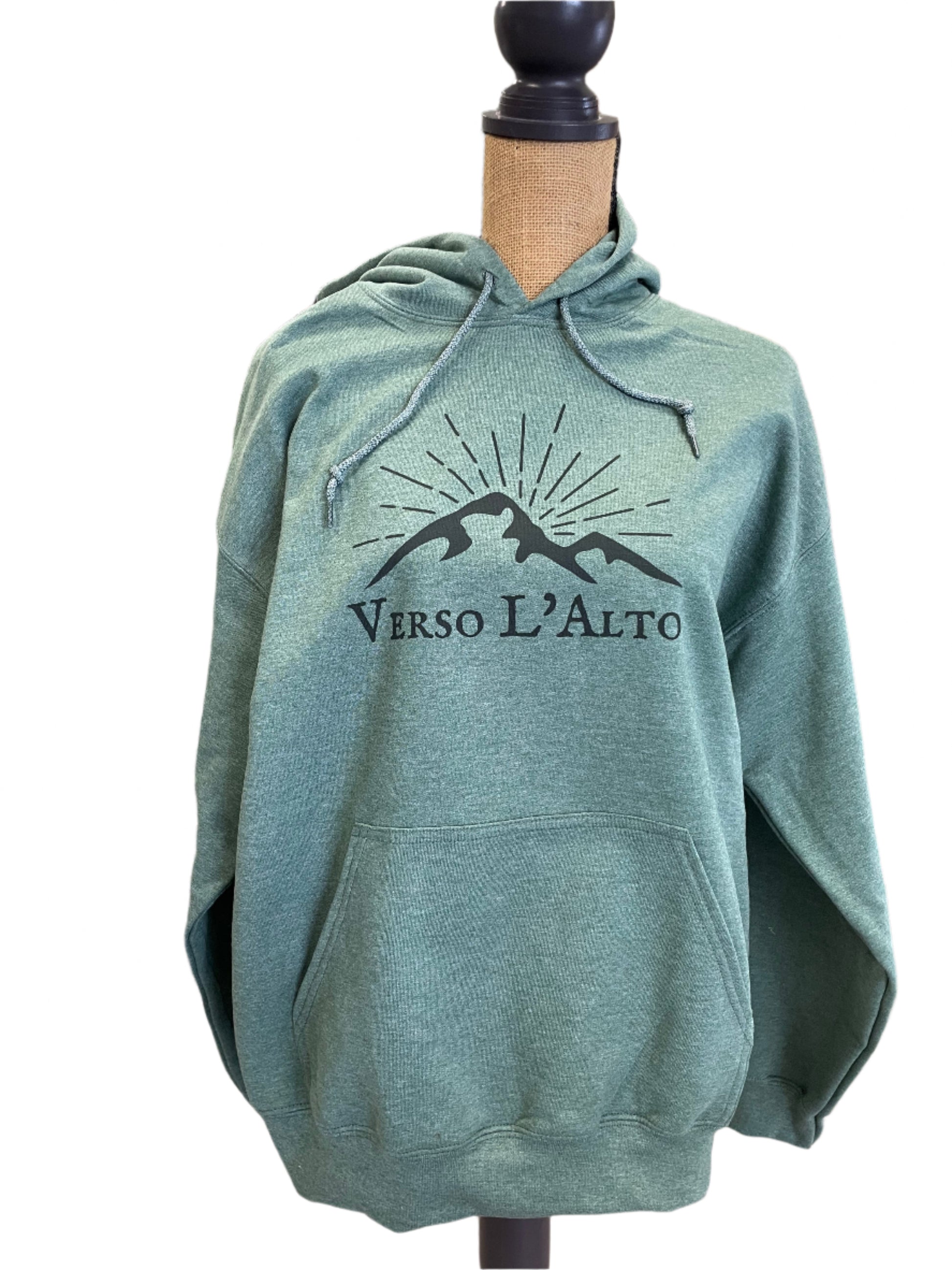 Green hoodie with a logo and text on a table in a room setting