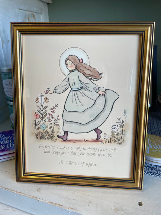 Framed artwork of a woman with a child, surrounded by text and floral elements.