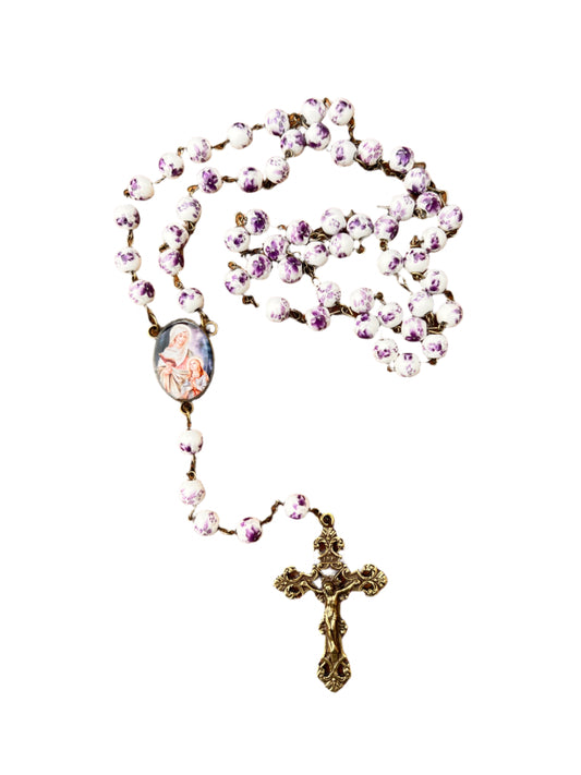Rosary with pink beads and a cross on a white background