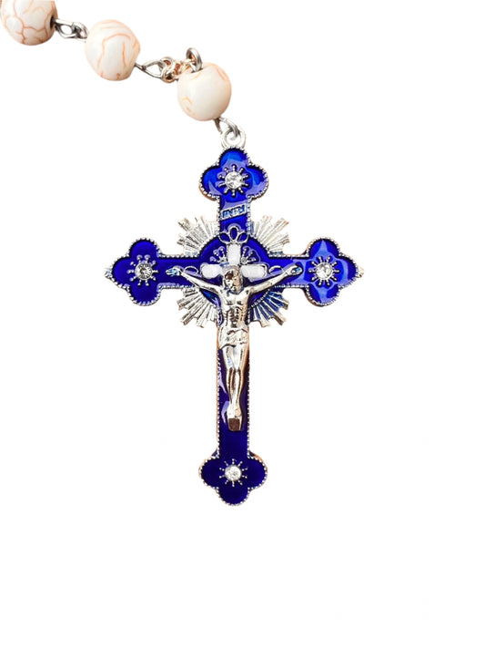 Blue and silver cross pendant on a white background
