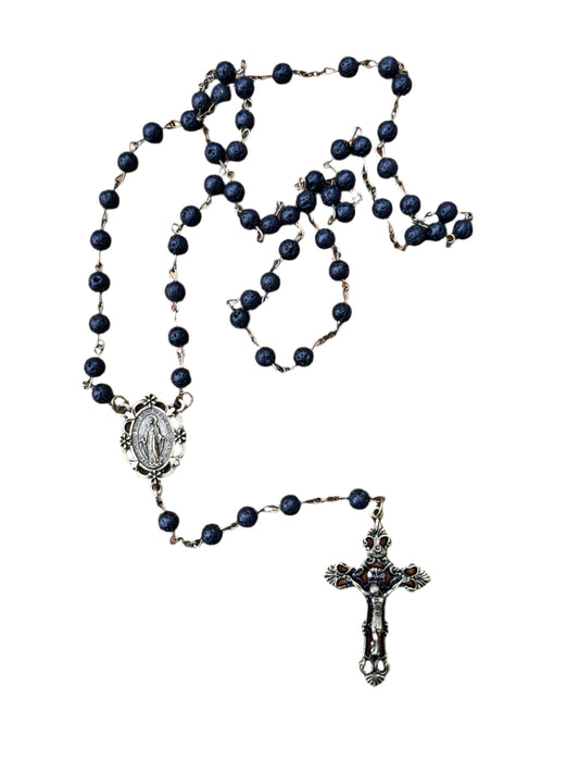 Black rosary with silver crucifix and  miraculous medal on a white background