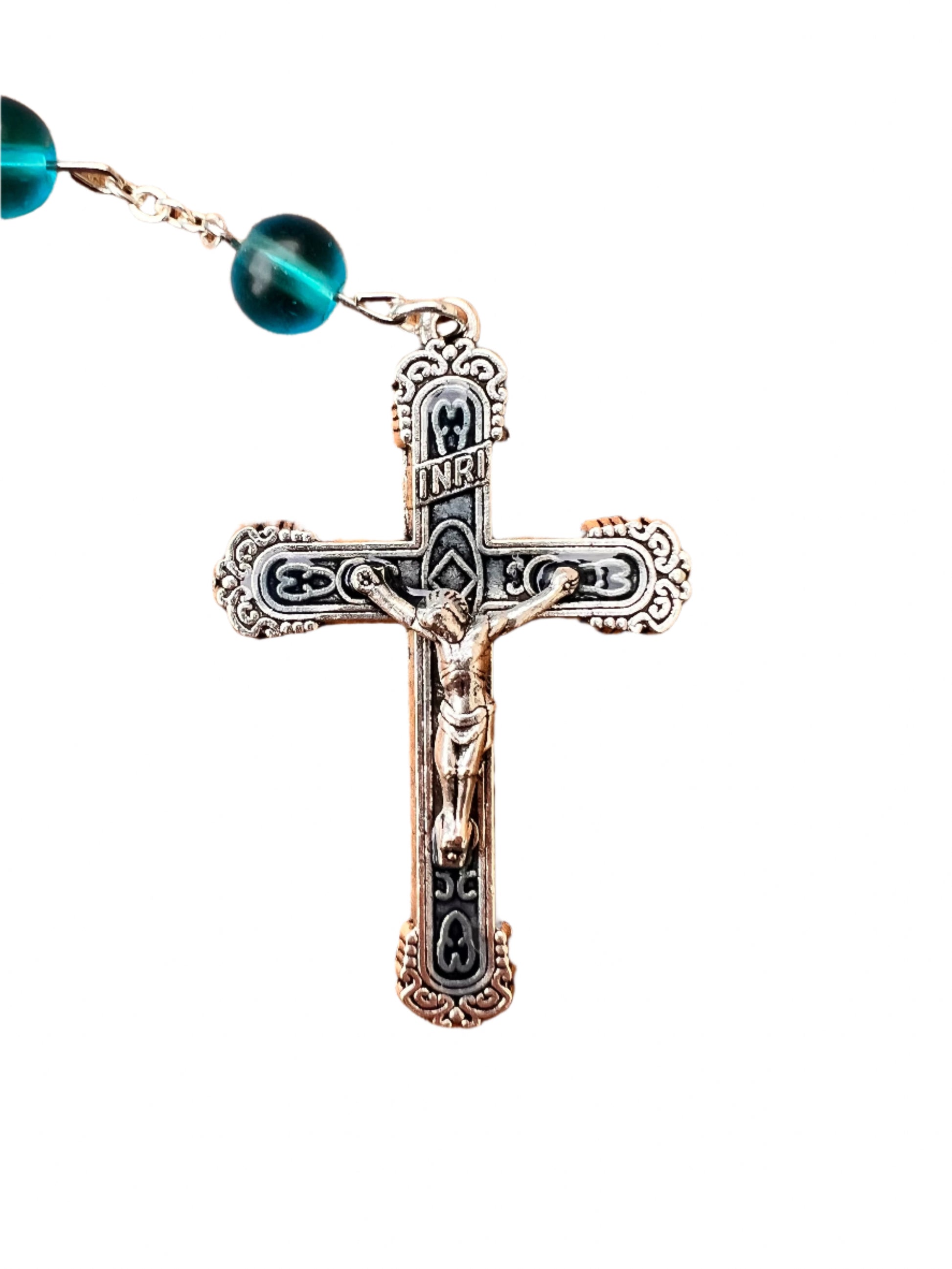 Decorative cross pendant with blue beads on a white background