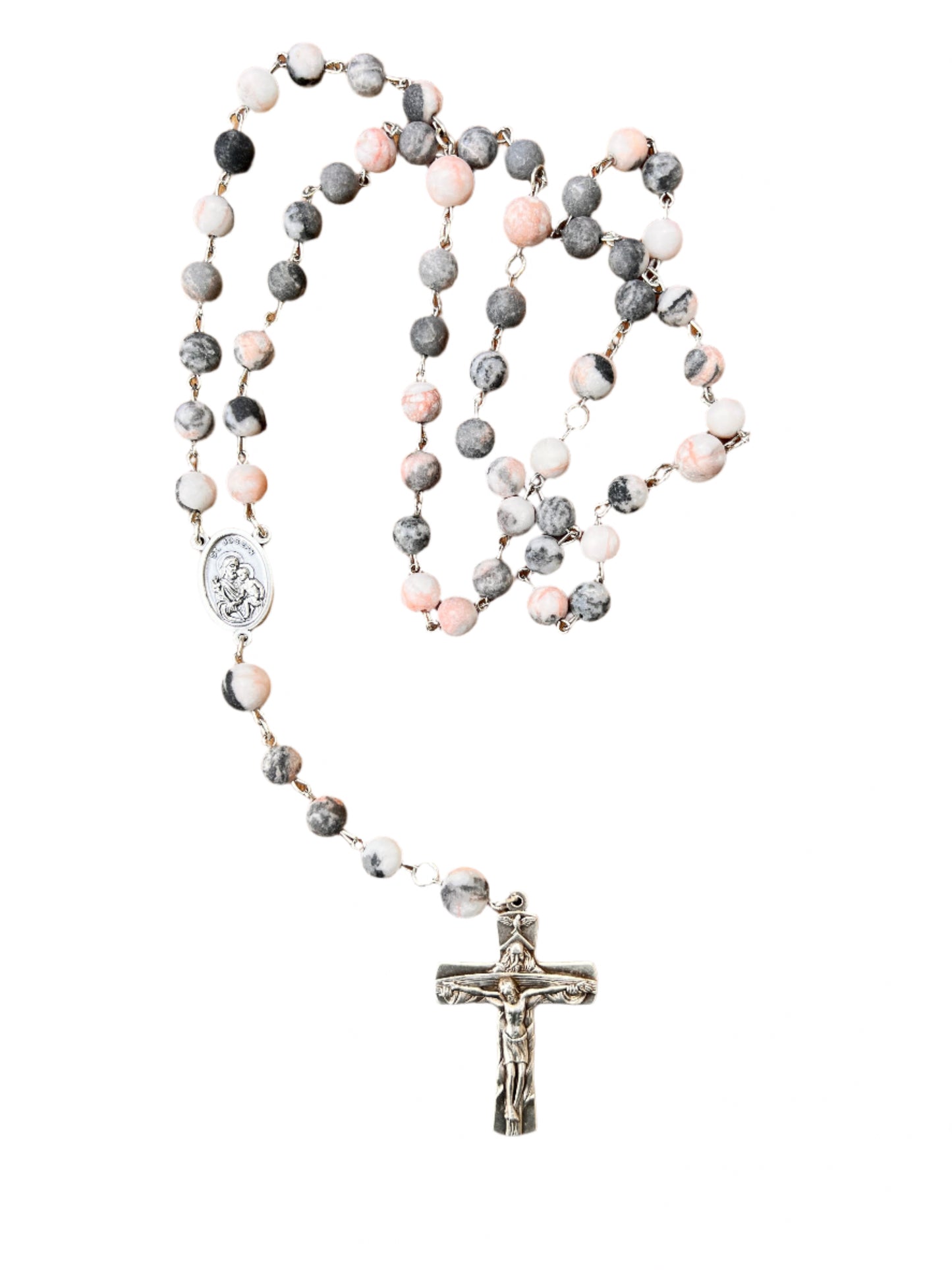 Rosary with multicolored beads and a silver cross on a wooden surface