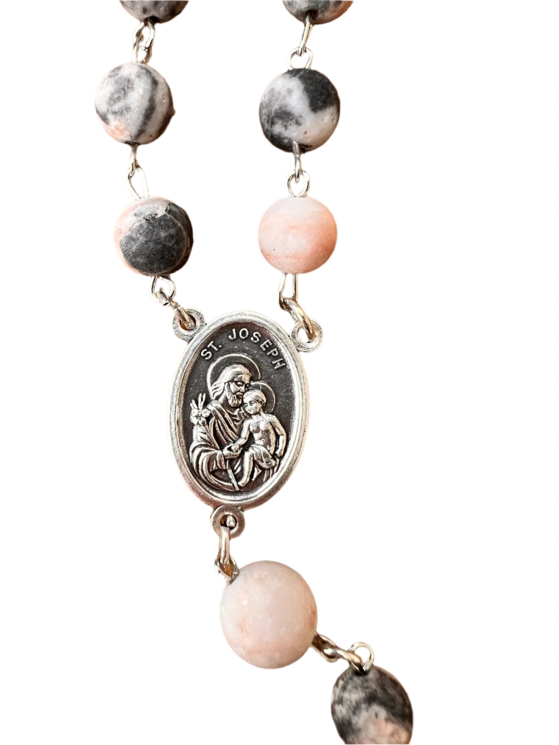 Necklace with pink and gray beads on a wooden surface