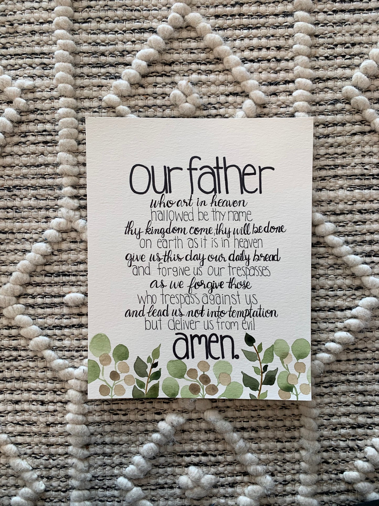 Card with text and green leaf design on a textured surface