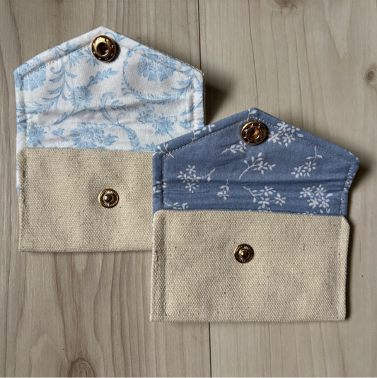Two fabric Rosary pouches on a wooden surface 