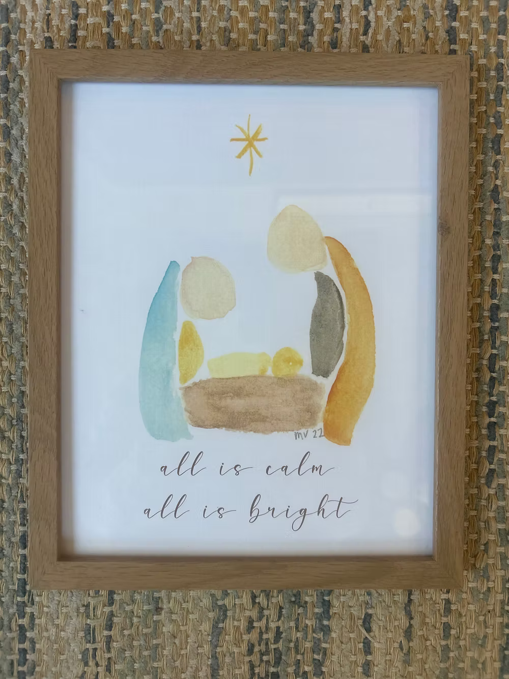Framed water color nativity scene print on wooden table