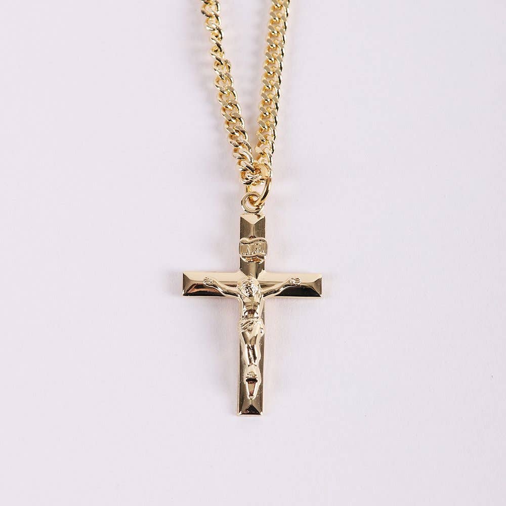 Gold crucifix pendant on a chain against a light purple background