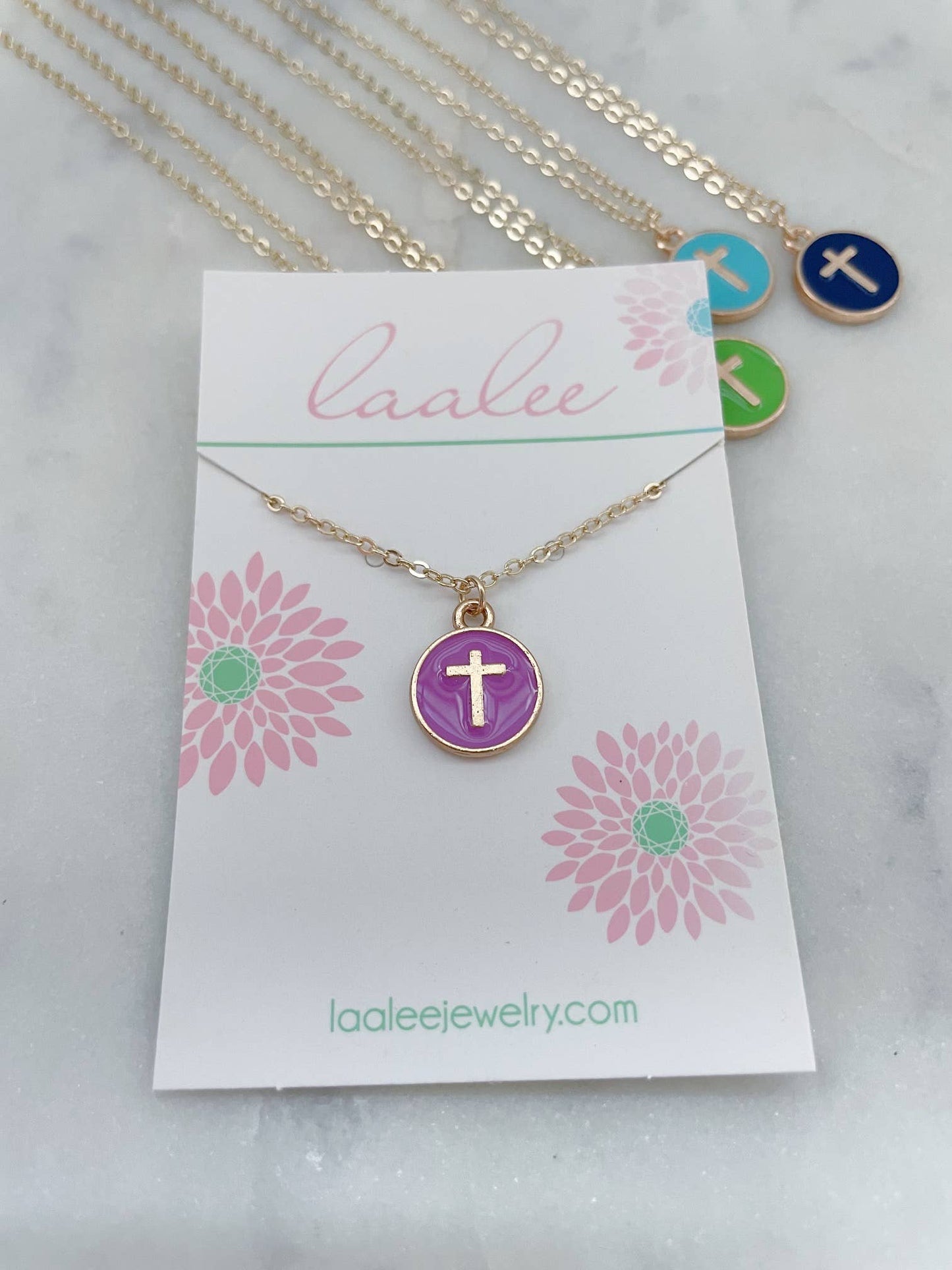 Necklace with a cross pendant on a 'Laalee' branded card with floral designs.