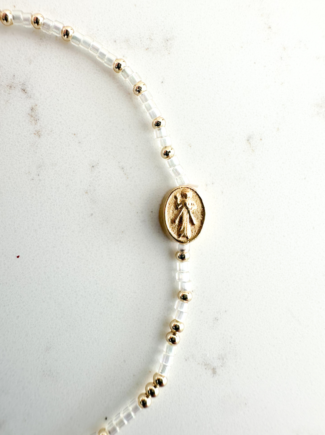 Necklace with gold and pearl beads on a marble surface