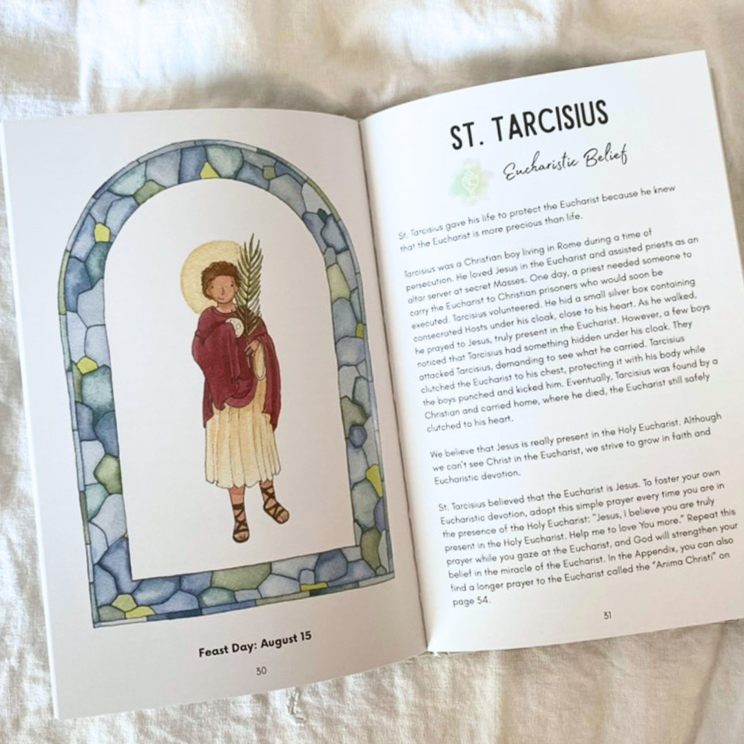Open book with illustration of St. Tarcisius and text on a white surface