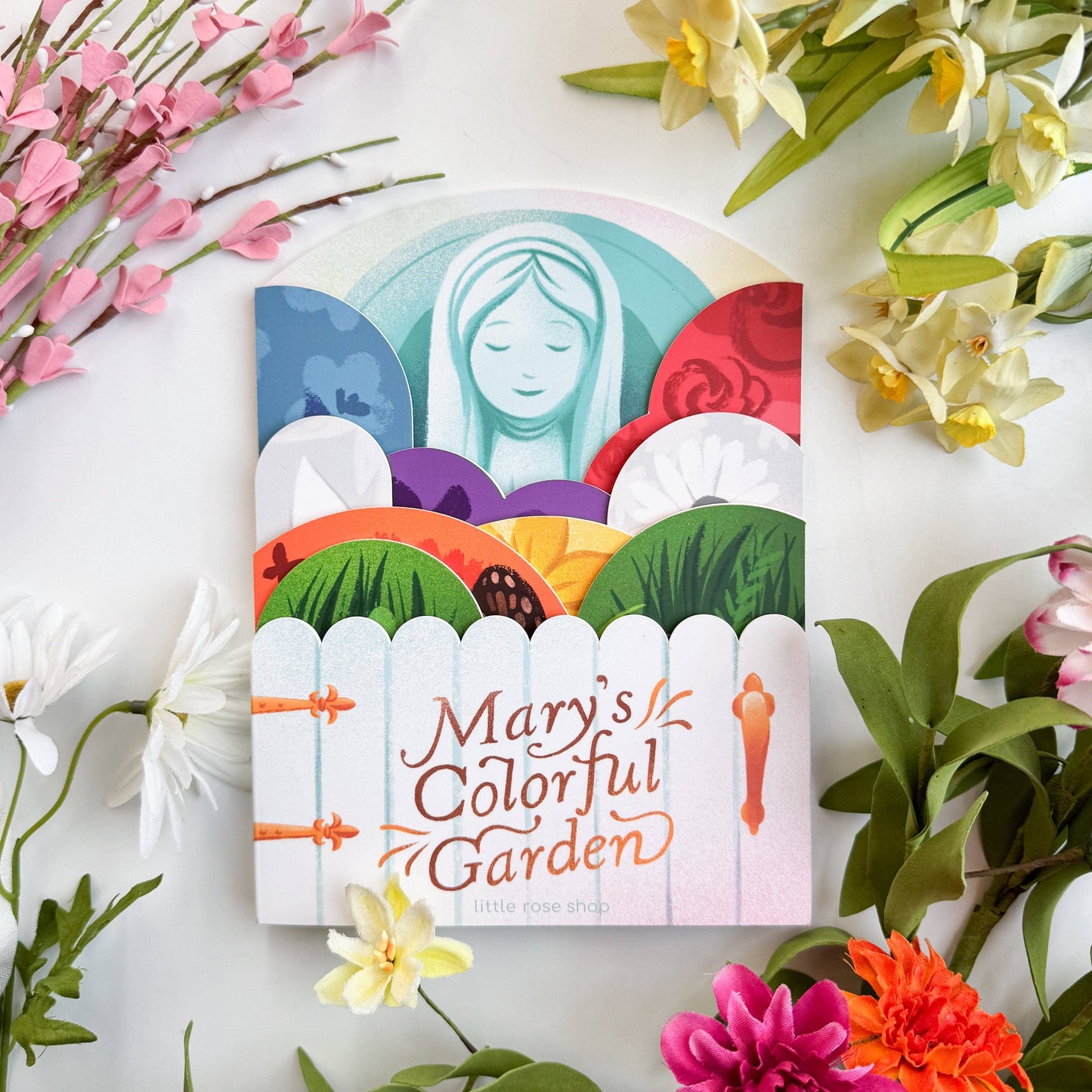 Children's book titled 'Mary's Colorful Garden' surrounded by flowers on a white background