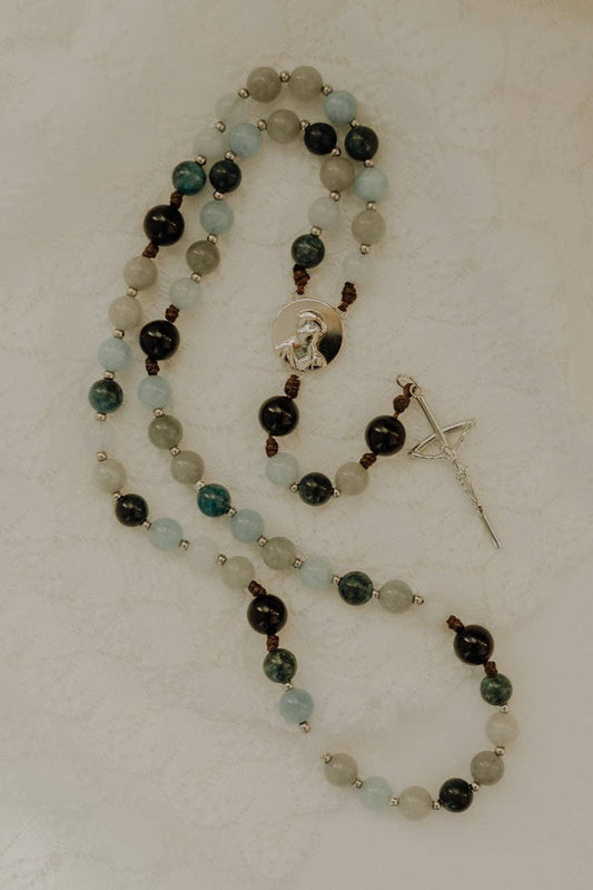 Beaded rosary with a cross pendant on a light background
