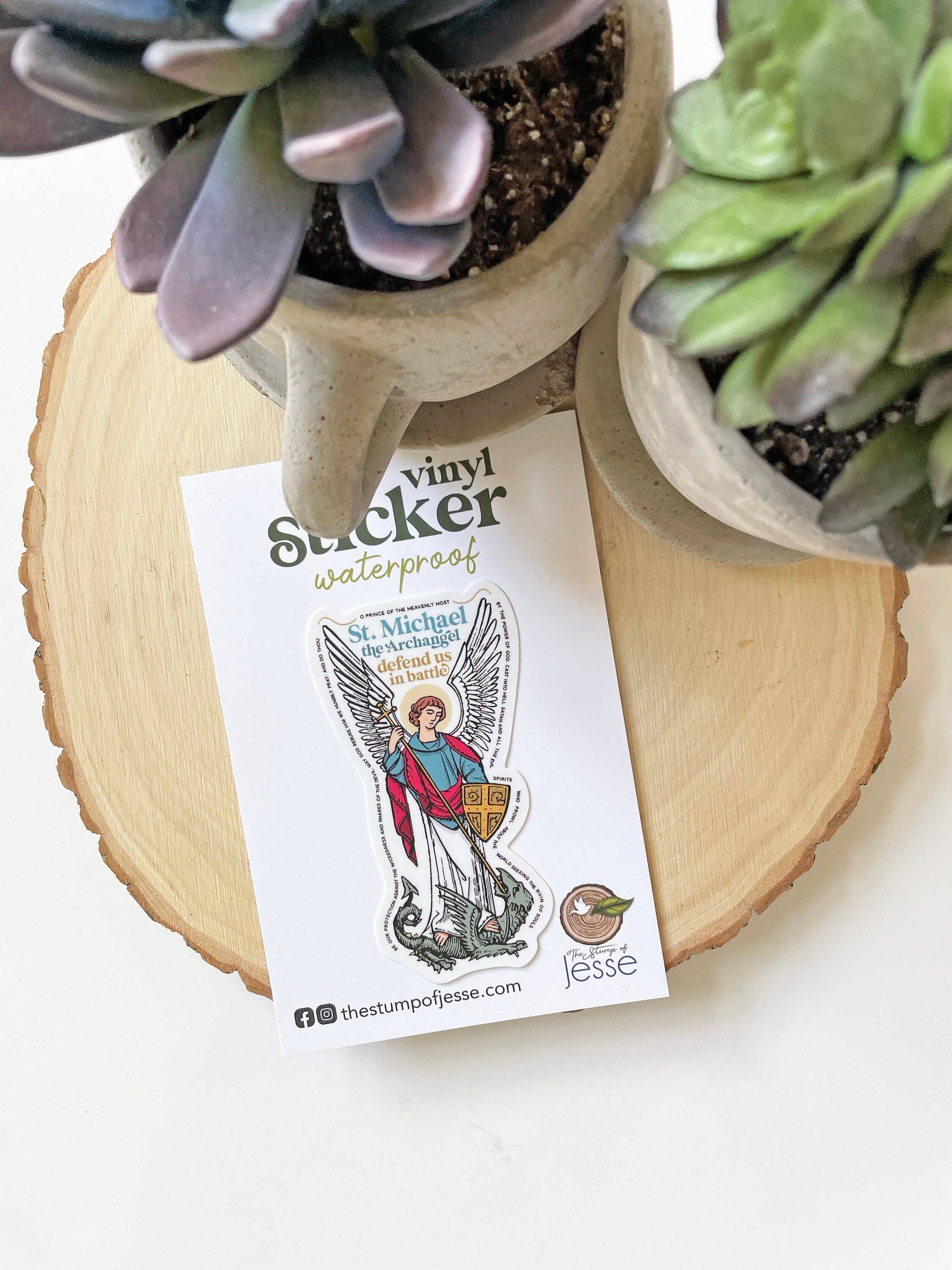 Vinyl sticker with an angel design on a card, surrounded by potted plants.
