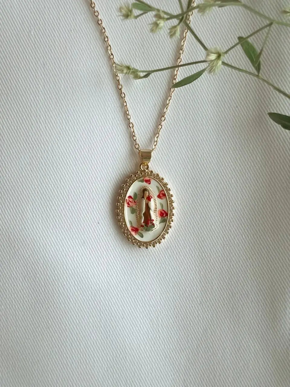 Necklace with a pendant featuring a religious design on a light background