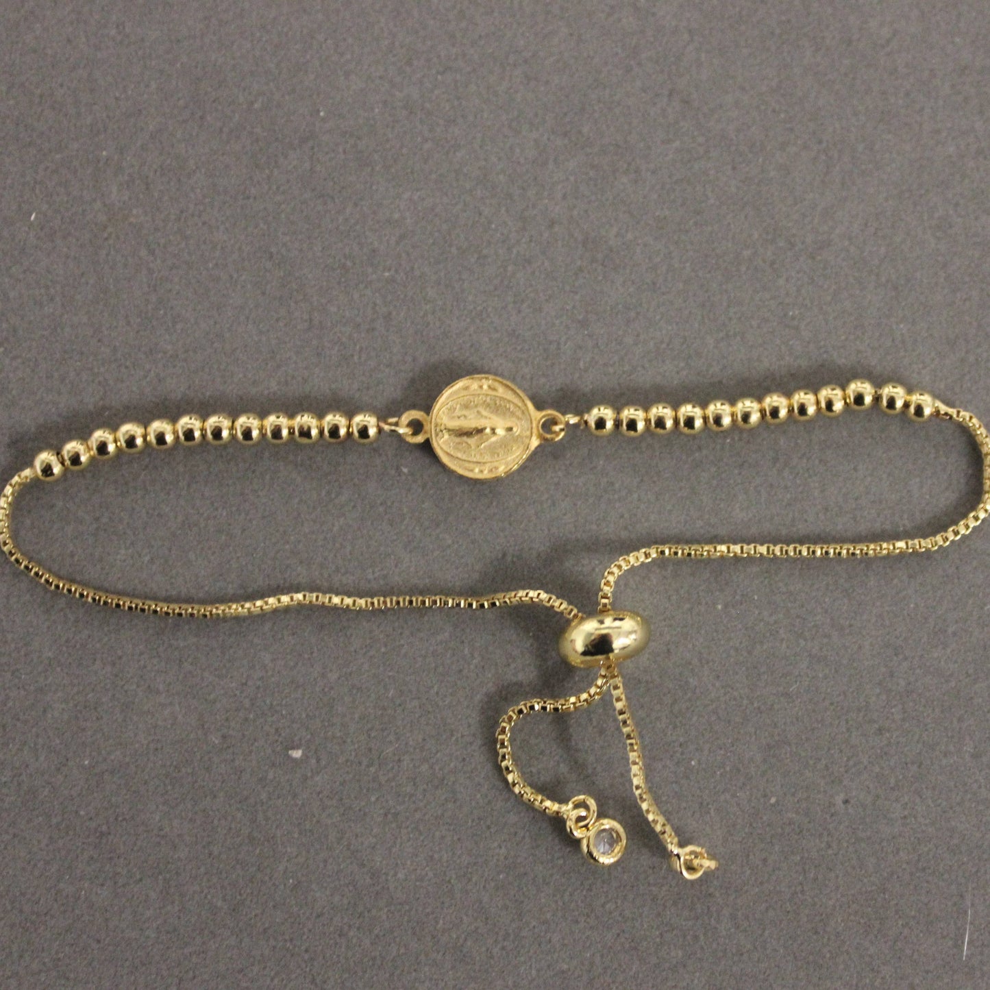 Gold bracelet on a gray background