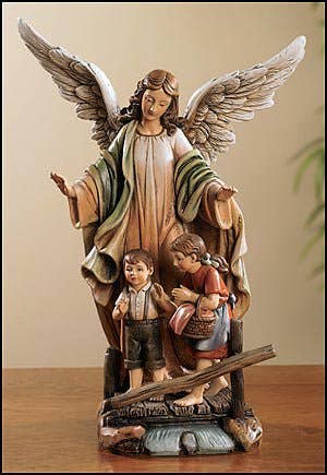 Statue of an angel with two children on a wooden table