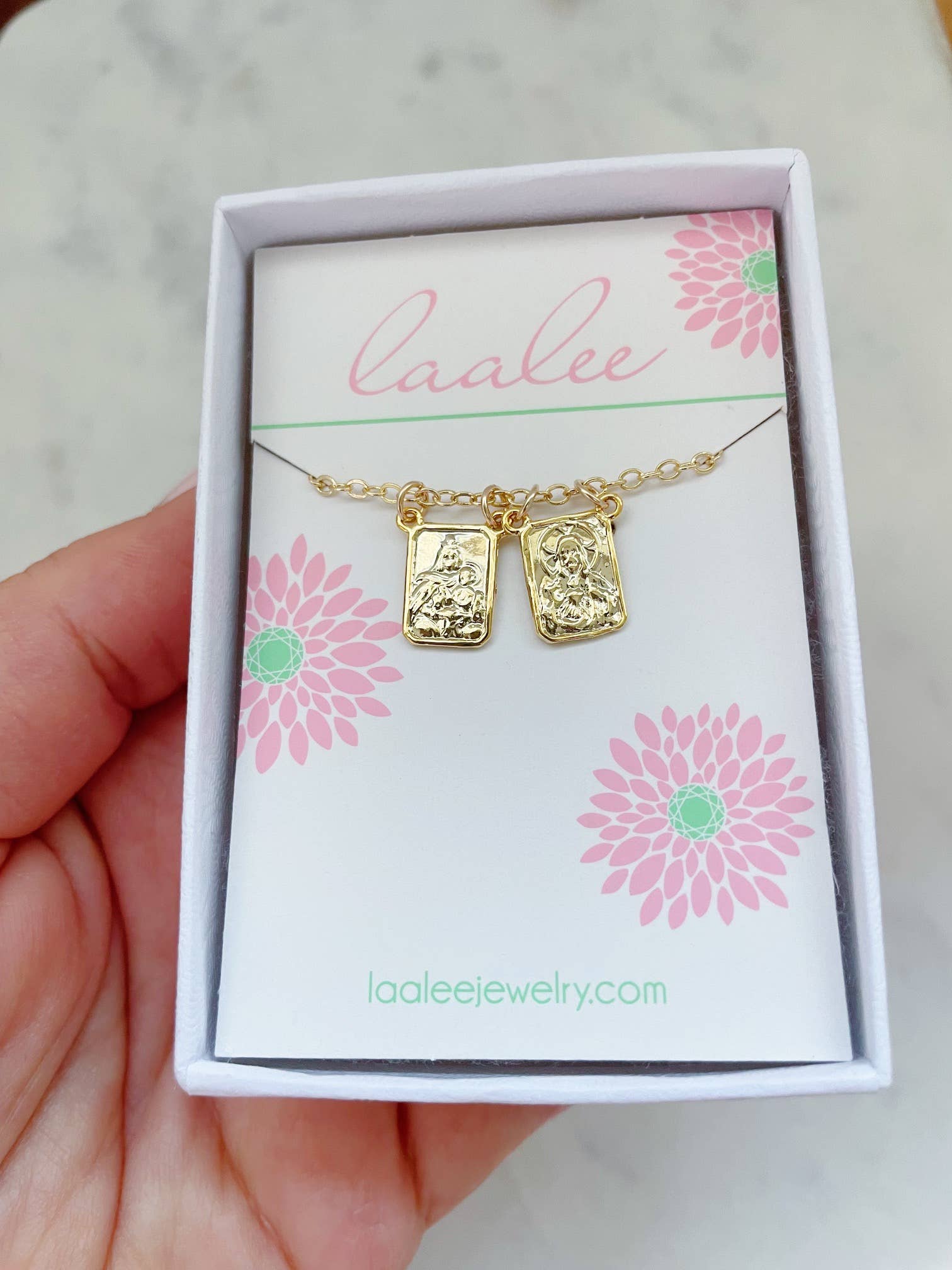 Gold necklace with pendant on a 'Laalee' branded card held by a hand.
