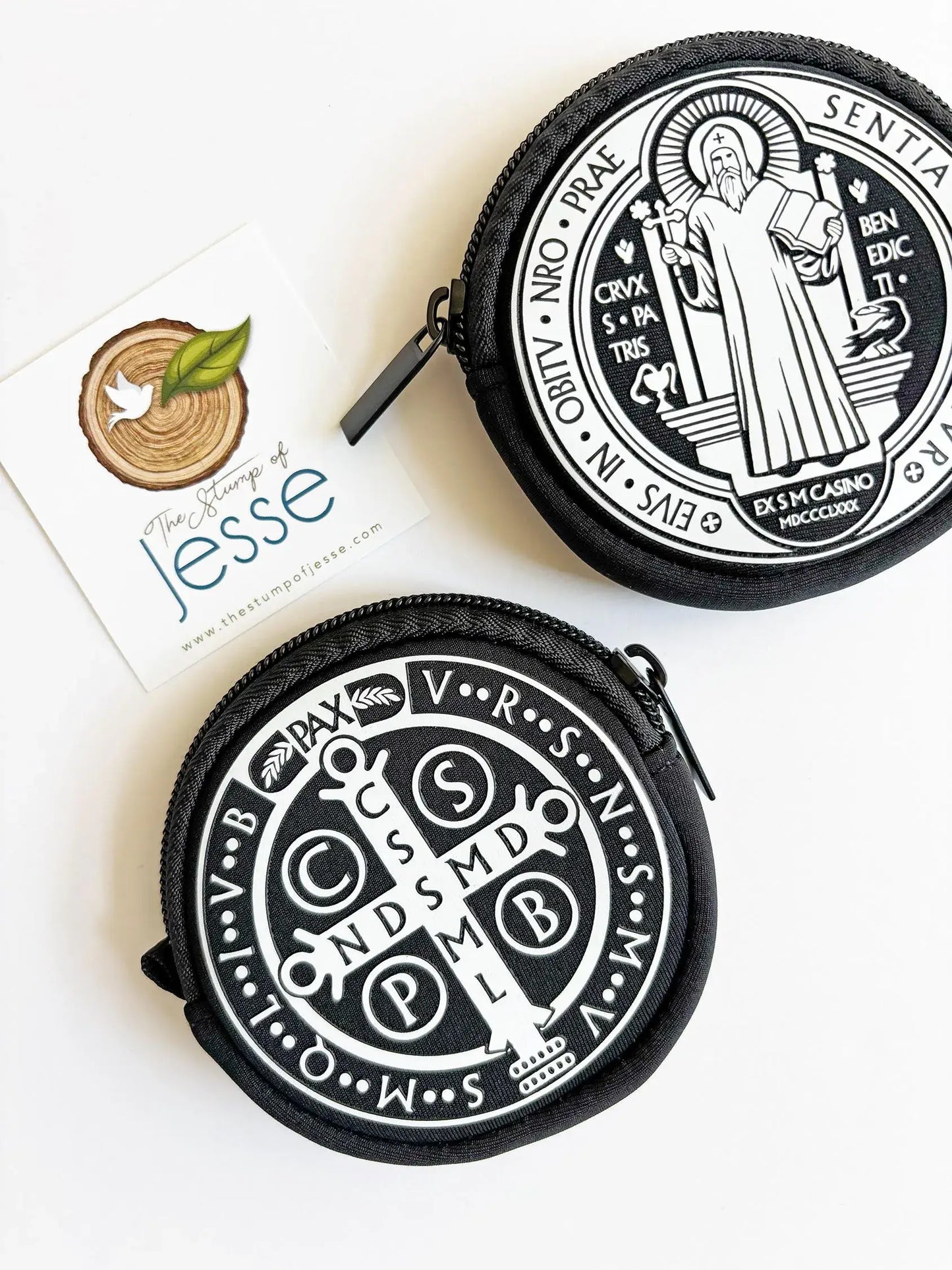Two black and white pouches with religious designs on a white background.