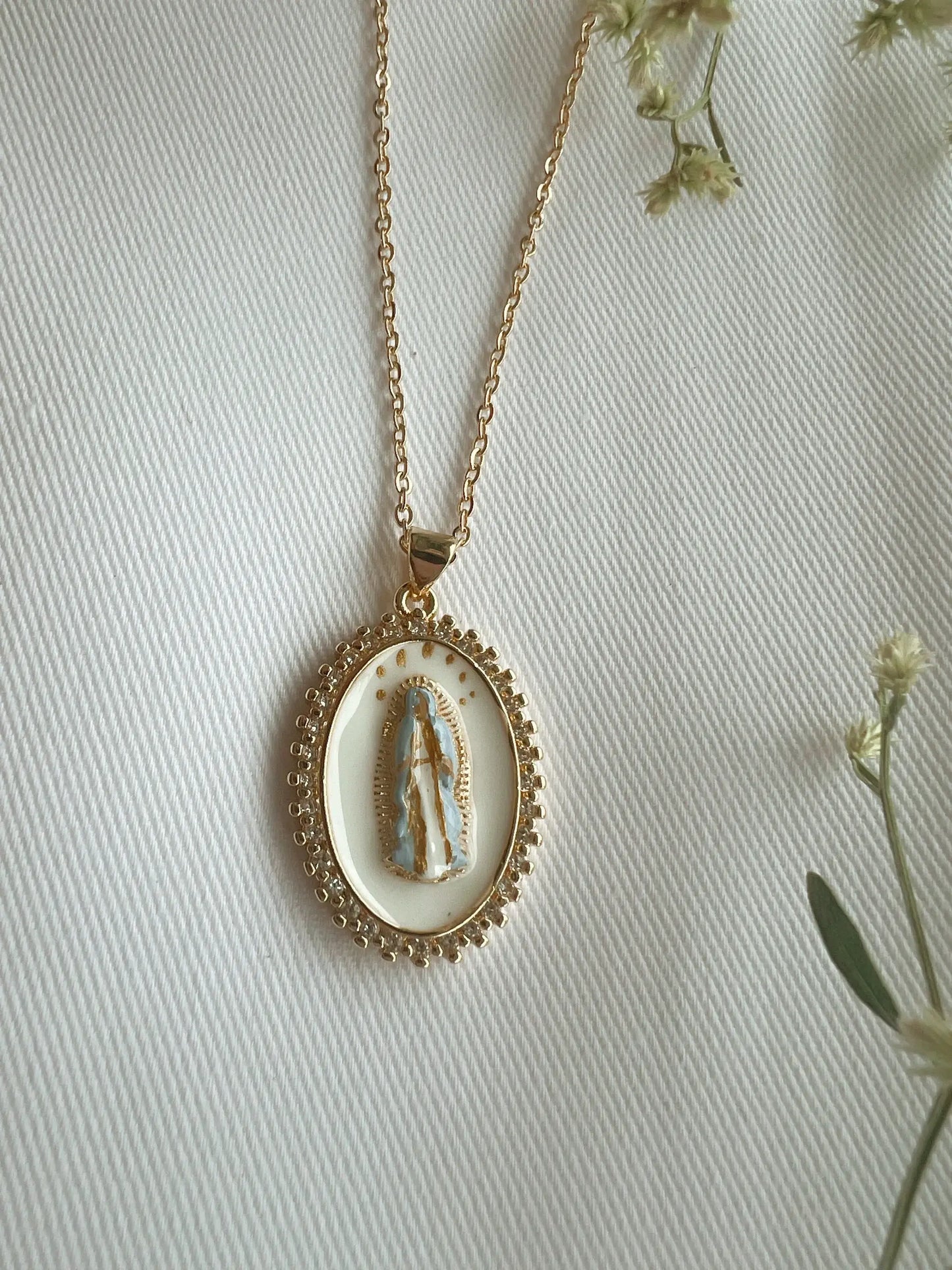 Gold necklace with a pendant on a light background