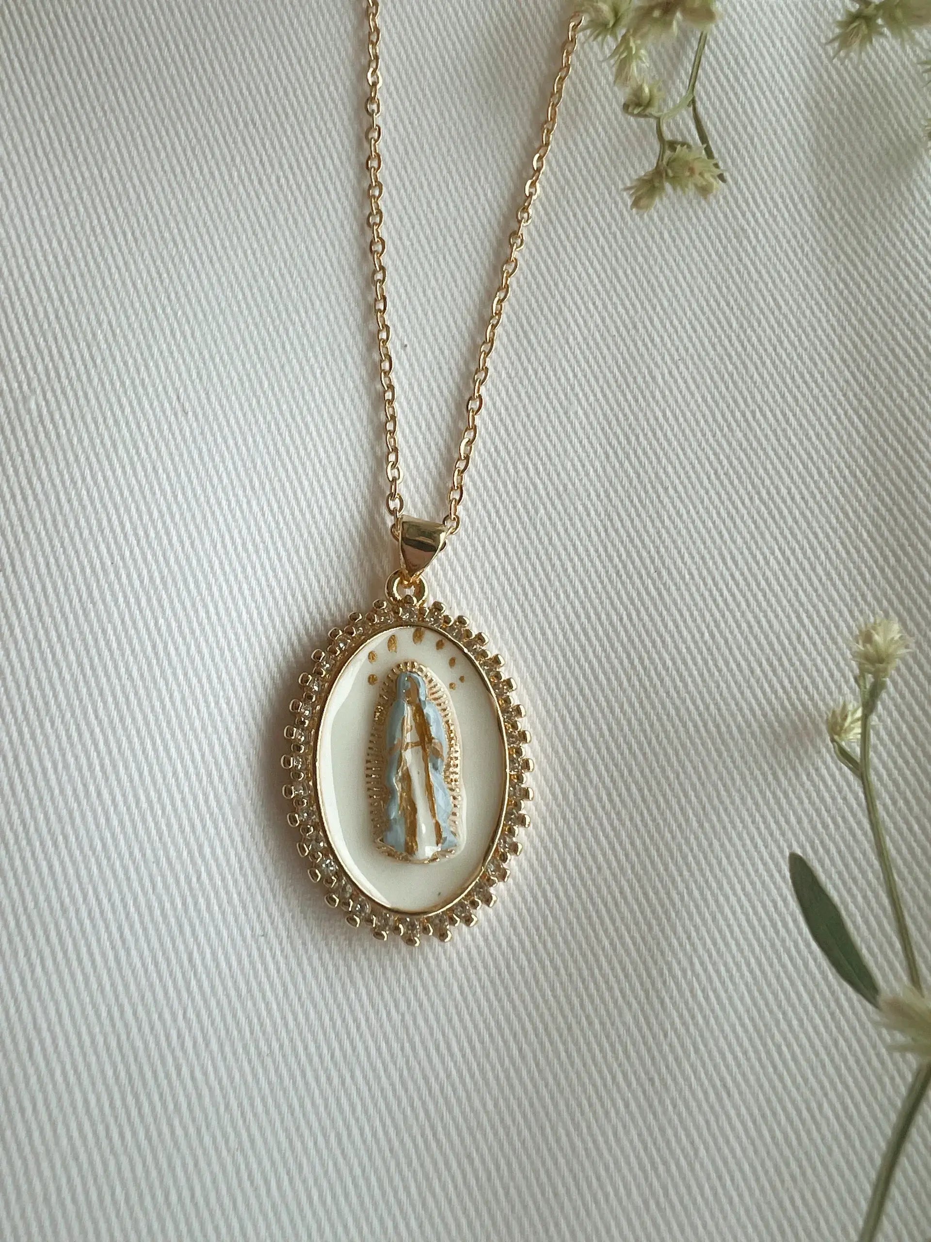 Gold necklace with a pendant on a light background