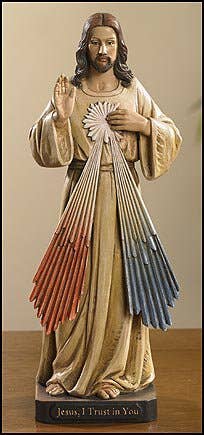 Statue of a religious figure with a colorful background on a wooden surface
